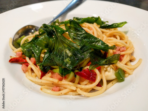 Close up of spaghetti bacon with crispy basil leaves