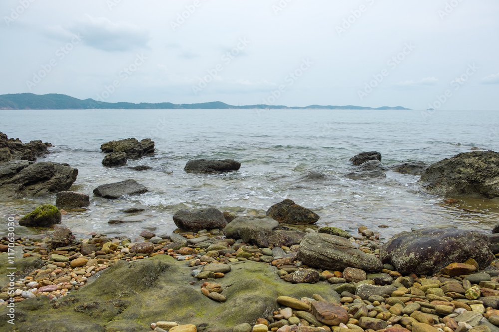 View of a sea coastline with stones and rocks View of a sea coastline with stones and rocks