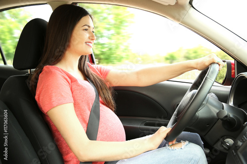 Pregnant woman driving car. Safety drive concept