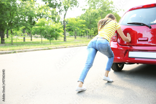 Woman pushing red car