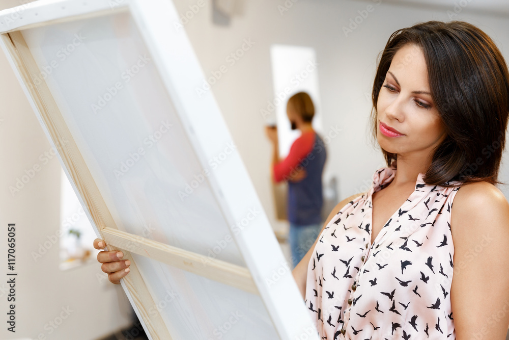 Young caucasian woman standing in art gallery front of paintings Young caucasian woman standing in art gallery front of paintings
