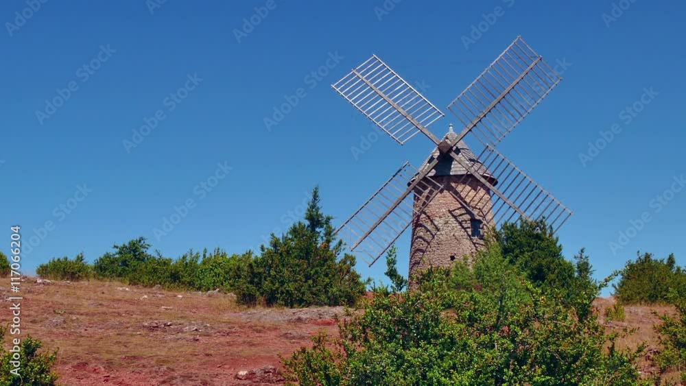 View of windmill near the traditional medieval village of La Couvertoirade, southern France. Beautiful typical French town, monument and tourist attraction. Travel, holiday in Europe