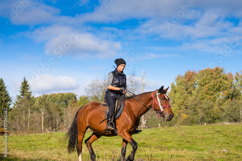 Elegant attractive woman riding a horse © AnnaMoskvina