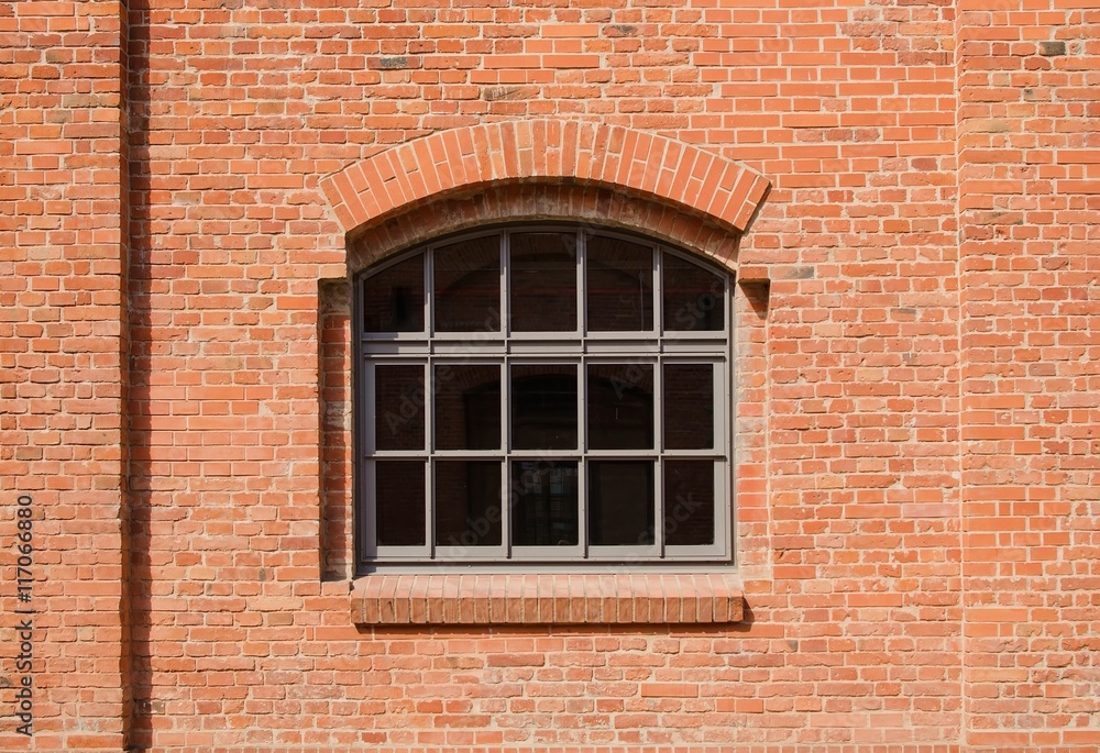 The window in red brick wall./ Rural arch the window in a red brick wall building.