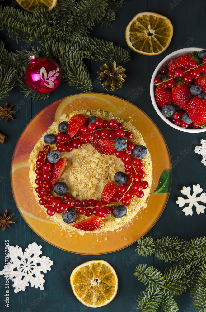 Napoleon cake with berries and fruit on wooden background. to celebrate Christmas or New Year decorated with fir branches, cones. Top view. Napoleon cake with berries and fruit on wooden background. to celebrate Christmas or New Year decorated with fir branches, cones. Top view.