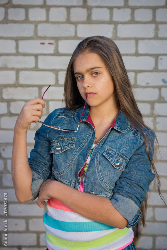 Portrait of fashionable teen girl with long hair on a background of a brick wall
Portrait of fashionable teen girl with long hair on a background of a brick wall