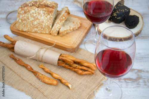 Wine, bread and wheat on the wooden table
