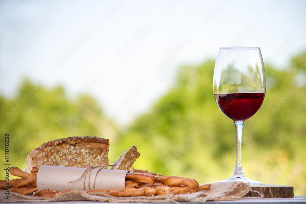 Wine, bread and wheat on the wooden table
