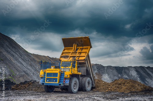 NOVOKUZNETSK  RUSSIA - JULY 26  2016  Big yellow mining trucks and excavators at worksite  