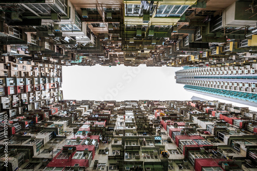 Hong Kong - May 31, 2015 : Back of crowded buildings stand surrounded the small common area, shooting in vertical view compares with modern building in Hong Kong.
