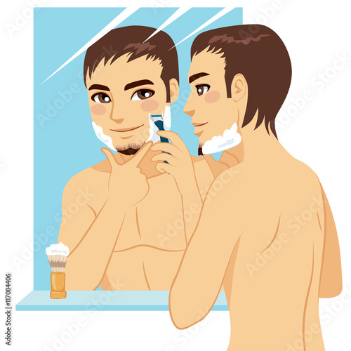 Handsome man shaving his face with razor after applying foam cream in front of mirror