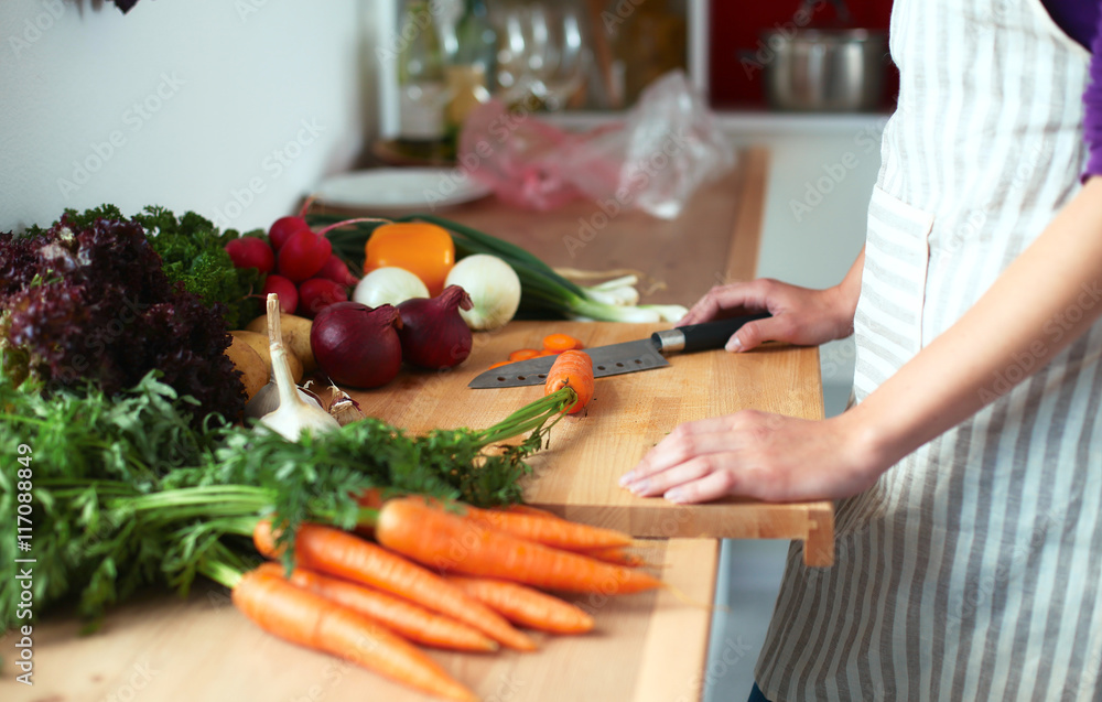 Young woman cutting vegetables in the kitchen Young woman cutting vegetables in the kitchen