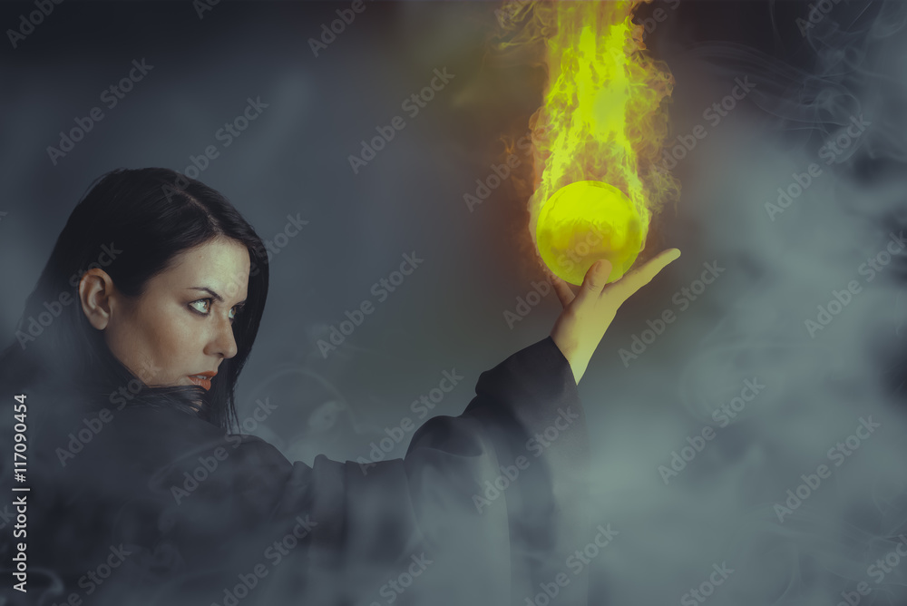 Magician woman with a fire ball in her hands