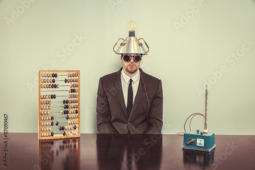Businessman sitting at office desk with abacus