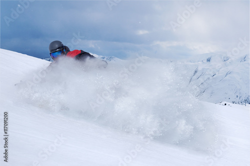 Snowboarder riding fast on dry snow freeride slope.