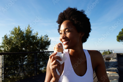 Active woman enjoying eating ice cream at the beach