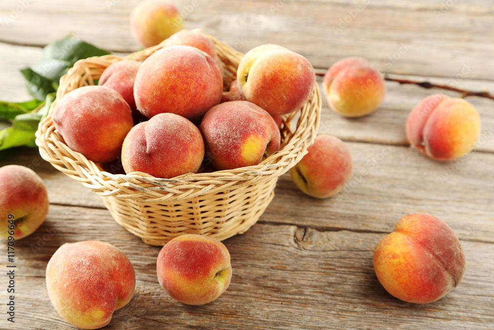 Sweet peach fruit in basket on grey wooden table Sweet peach fruit in basket on grey wooden table