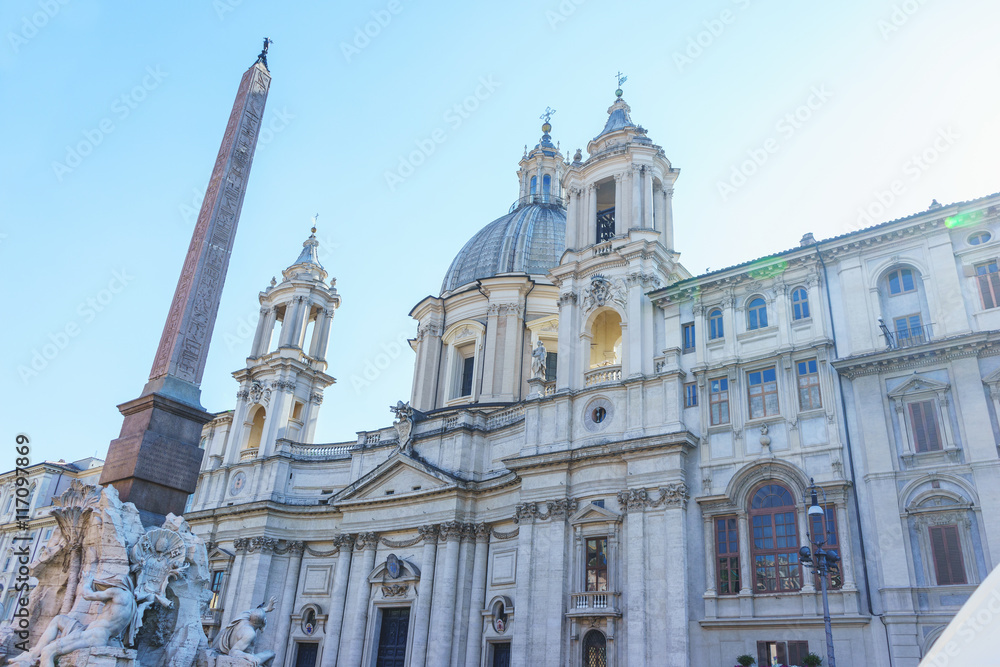 Ancient Egyptian Monument and Church of Sant'Agnese de Agony in the baroque Piazza Navona in Rome. Italy. Part of the facade of the cathedral and a monument on the Piazza Navona.
