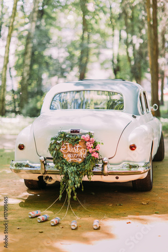 Bumper of retro car with just married sign and cans attached