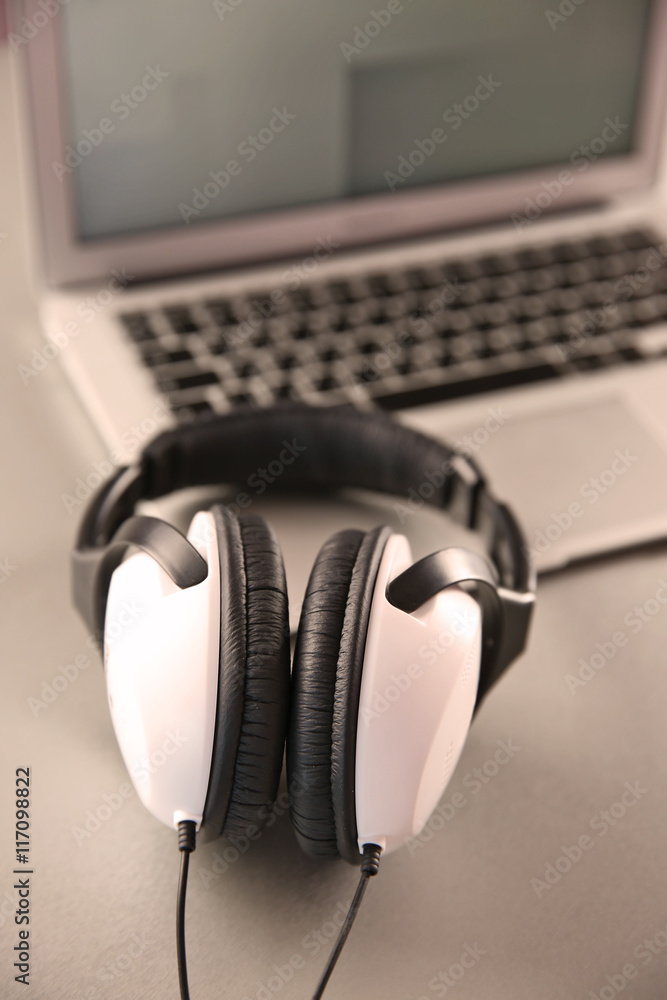 Headphones and laptop on table closeup Headphones and laptop on table closeup