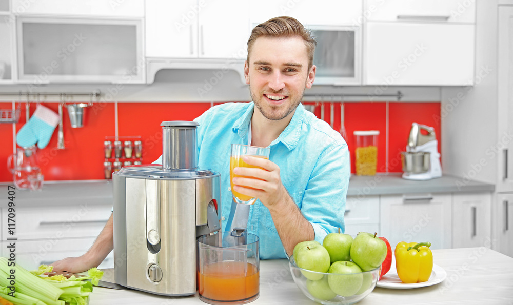 Handsome man with juice in kitchen Handsome man with juice in kitchen