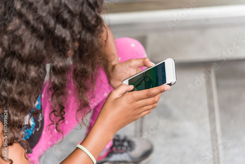 App game playing child with smartphone outside. Young girl walking on street with smartphone searching for app monsters in internet game