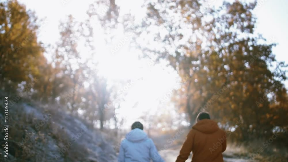 Happy couple having fun outdoors. Couple walk away. Countryside. Sun flare Happy couple having fun outdoors. Couple walk away. Countryside. Sun flare