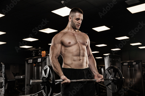 very power athletic guy bodybuilder , execute exercise with dumbbells