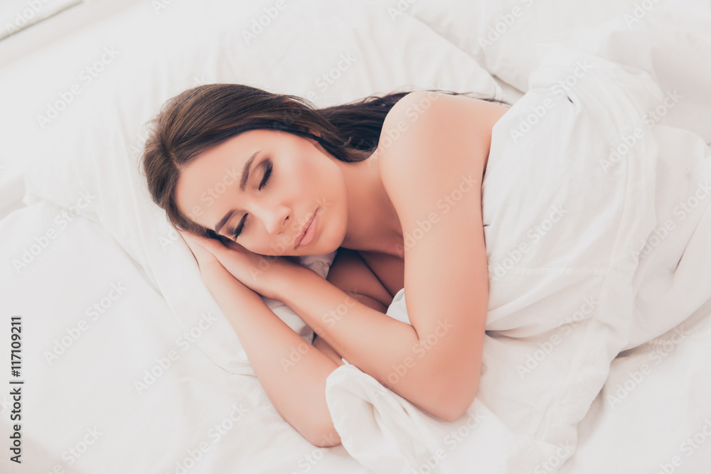 Relaxed young woman sleeping on fresh white bed Relaxed young woman sleeping on fresh white bed