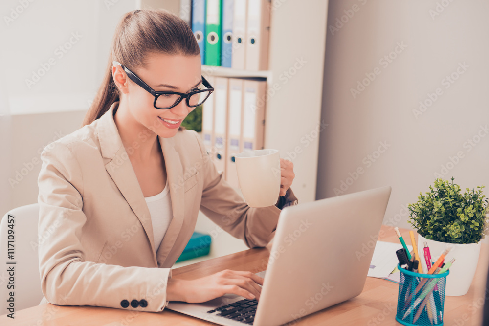 Portrait of beautiful young woman working with laptop and drinki Portrait of beautiful young woman working with laptop and drinki