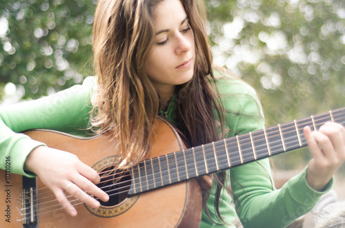 Mujer tocando la guitarra al aire libre