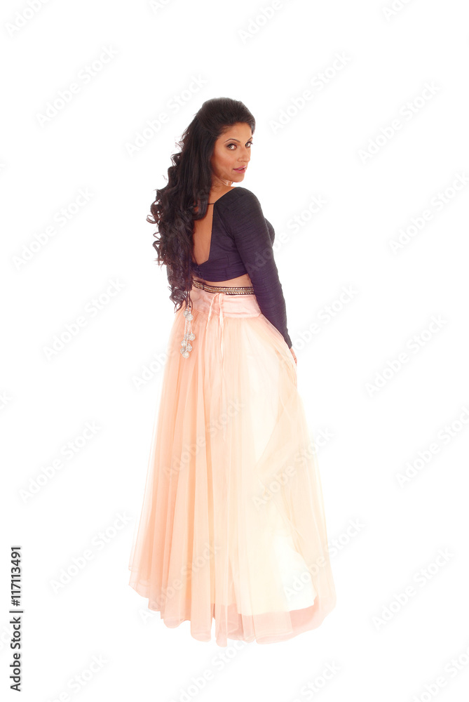Woman standing in long pink skirt.