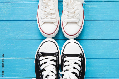 Two pairs of canvas shoes on a blue wooden