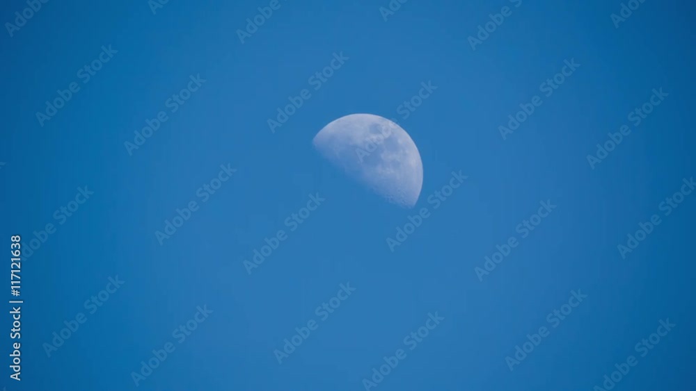 half moon moving across a blue sky half moon moving across a blue sky
