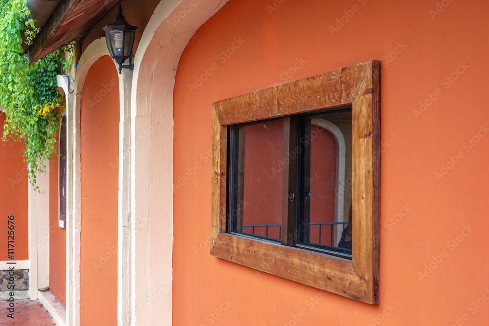 Wooden framed window on orange wall