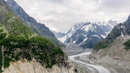 Timelapse of Mer de Glace glacier and Grandes Jorasses in the Mont Blanc massif during the cloud and rainy day in summer at Chamonix, French Alps