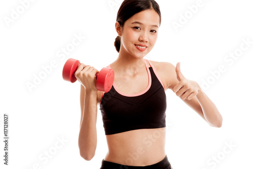 Beautiful Asian healthy girl thumbs up with dumbbell