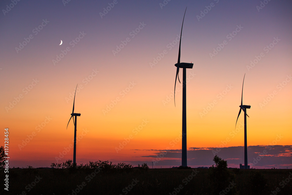 Obraz premium Wind turbine power generator silhouette at sunset