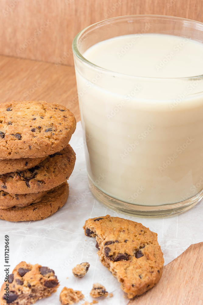 Chocolate chip cookies and a glass of milk on a wooden background. Chocolate chip cookies and a glass of milk on a wooden background.