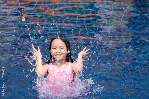 Asia kid girl at the pool and smiling happy