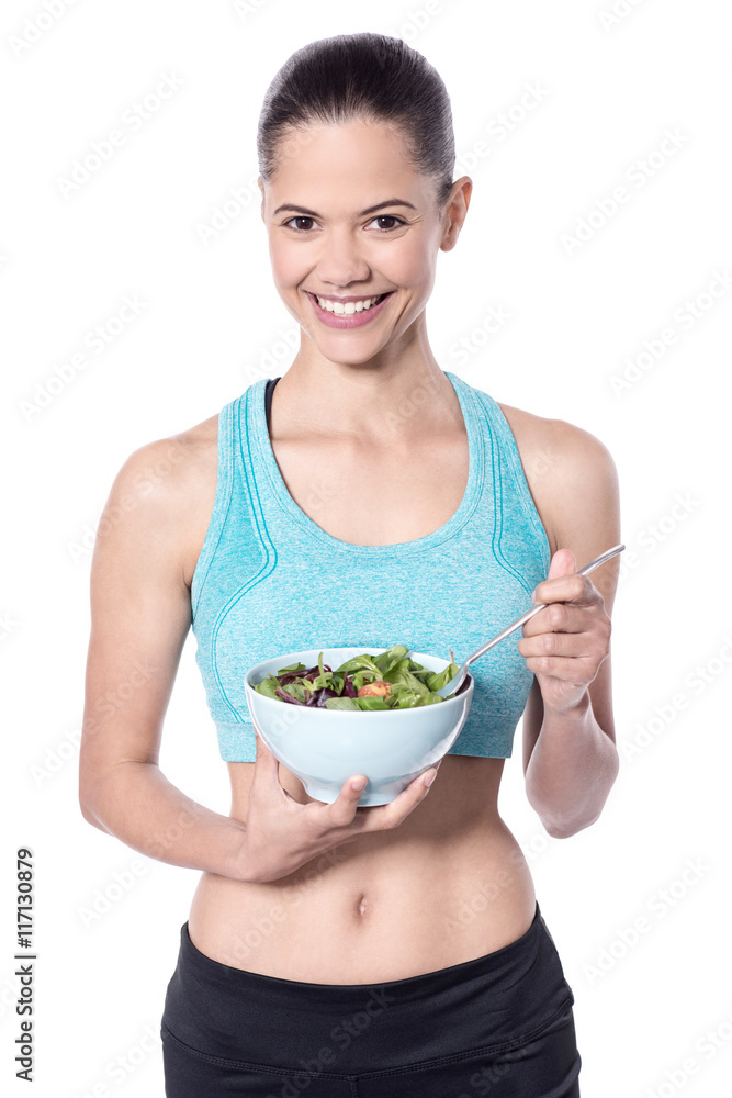 Woman with a bowl of salad looking at camera Woman with a bowl of salad looking at camera