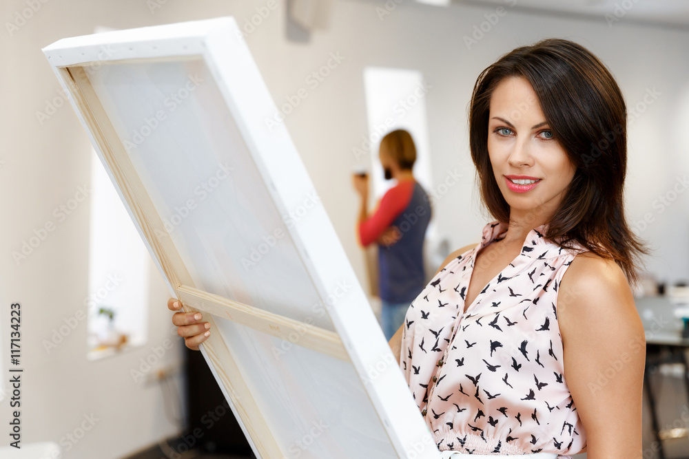 Young caucasian woman standing in art gallery front of paintings Young caucasian woman standing in art gallery front of paintings