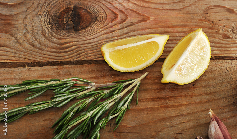 lemon, garlic and rosemary on a wooden background in rustic styl