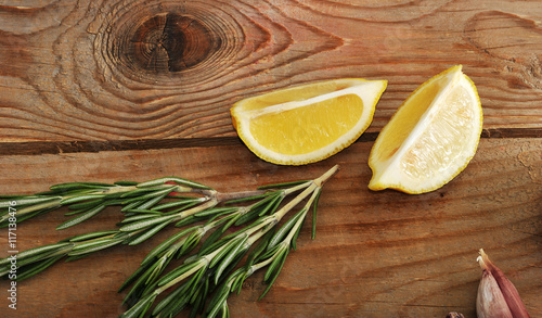 lemon, garlic and rosemary on a wooden background in rustic styl