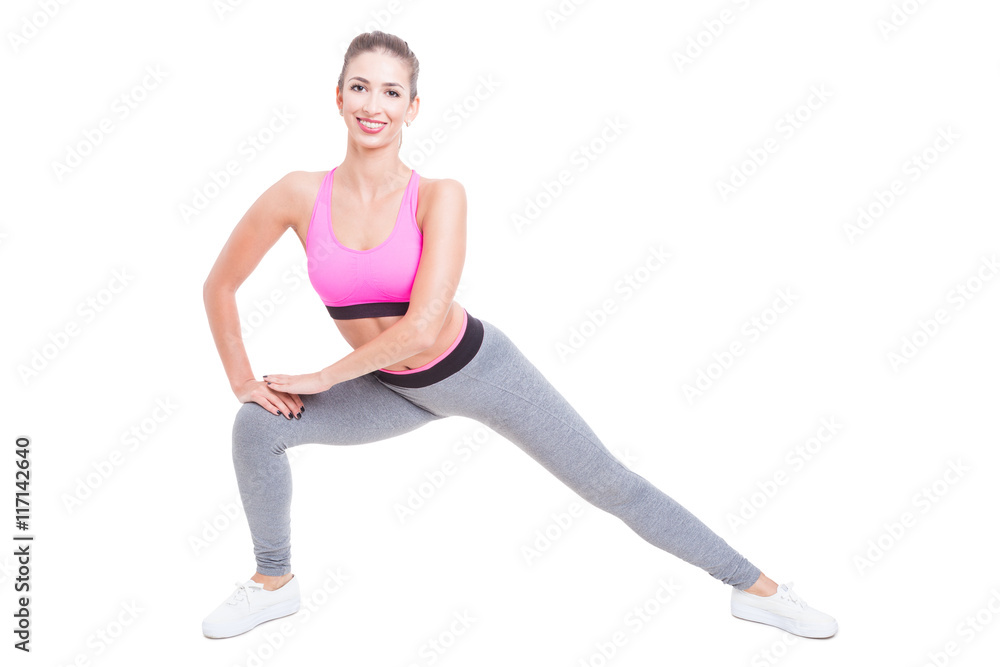 Female trainer making side lunges and smiling Female trainer making side lunges and smiling