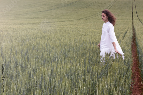 Spiritual daydreamer striding through a cornfield