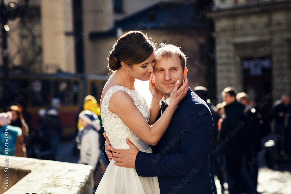 Pretty bride holds groom's face with her deilcate hands Pretty bride holds groom's face with her deilcate hands