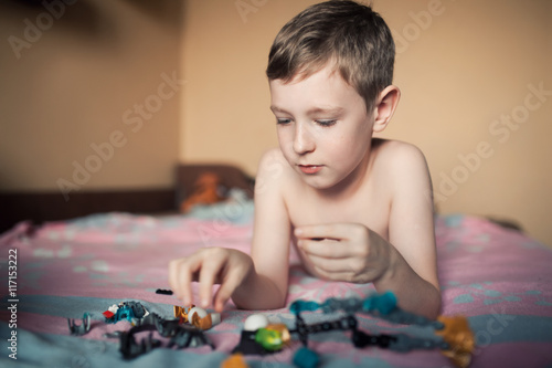 little boy playing with toys;