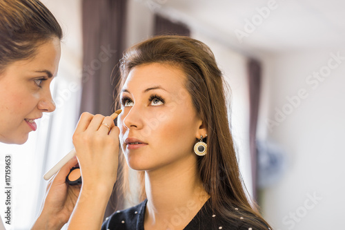 makeup artist applying make up on girl