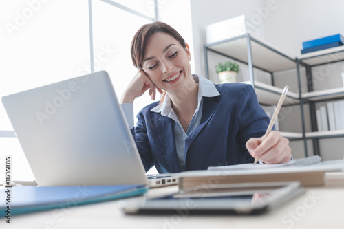 Businesswoman writing notes on a notebook